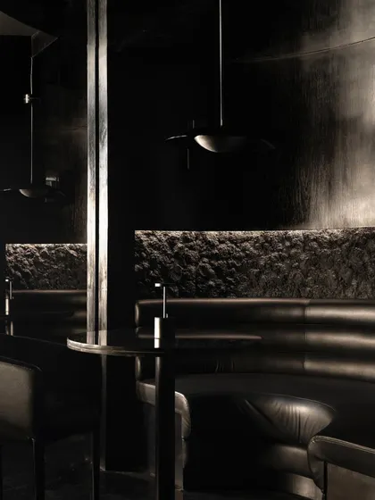 Details of the seating at Lair, where rough, rock-like textures meet smooth leather upholstery. This tactile contrast is central to the bar's sensory narrative.