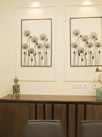 A dining area with a dark wood console table and framed black-and-white floral art. The design is simple, elegant, and timeless.