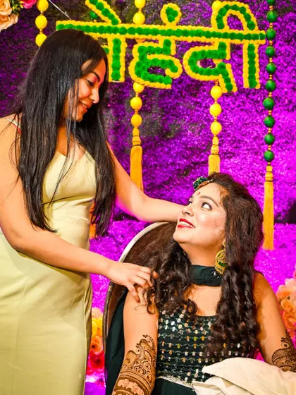 A sweet, candid interaction between the bride and her friend or sister during the Mehndi. We are always watching for these quiet, meaningful exchanges.