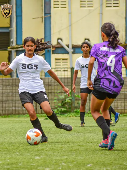 Another action shot from the girls' league, showing a player driving forward with the ball.