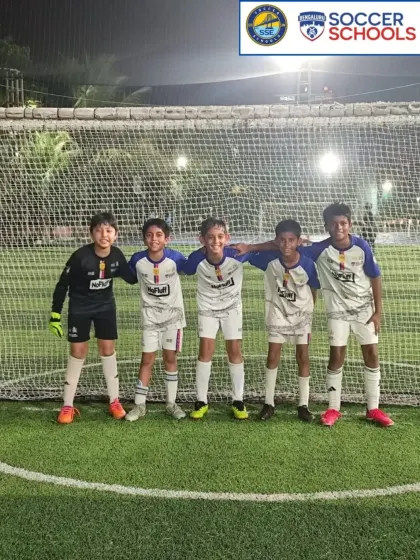 A U10 team photo under the lights after a match.