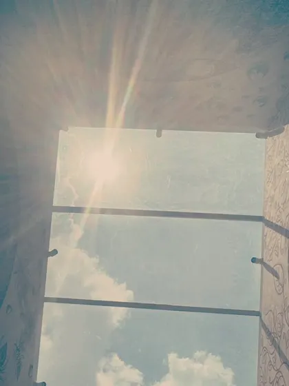 The sun's rays beaming through the skylight and hitting the top of the installation. This captures the dynamic quality of the project, where natural light becomes an active element of the artwork itself.