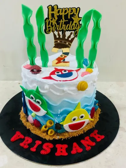 Doo doo doo doo doo doo! A fun Baby Shark cake featuring the whole shark family swimming in a buttercream ocean with edible seaweed and shells.