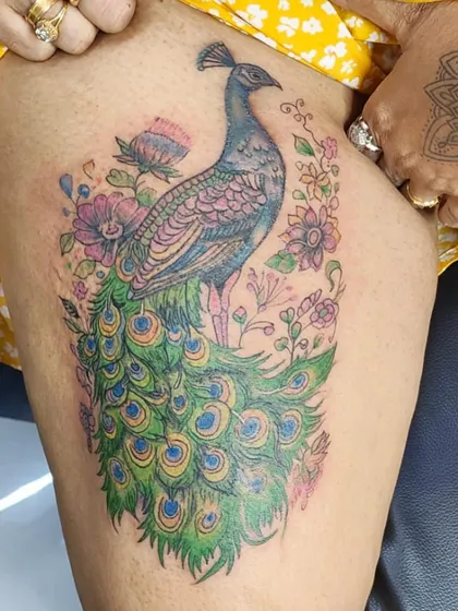 A royal peacock tattoo is a symbol of beauty and pride. I love working with color to create vibrant, timeless masterpieces like this one. We designed this piece to flow perfectly on the thigh, making it a bold and elegant statement.