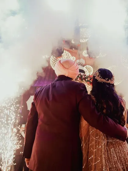 A powerful shot from behind the couple as they face the cheering crowd, surrounded by smoke and lights. A truly cinematic moment.