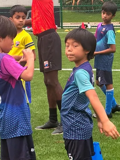 Young players listening intently to their coach. These moments of instruction are vital for development, helping kids understand the game and their role on the team.