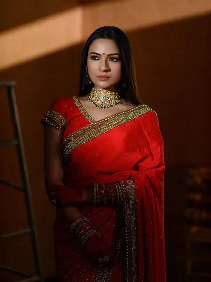 The power of red. This portrait, inspired by Sabyasachi's aesthetic, uses dramatic lighting to highlight a classic red saree. The concept of painted hands adds a deeply symbolic and artistic layer to this bridal theme.