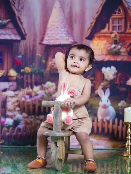 A little girl enjoys a ride on a wooden tricycle in our whimsical bunny village.
