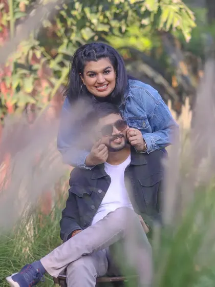 A fun and candid moment during a pre-wedding shoot, where the bride-to-be playfully frames her partner's face.