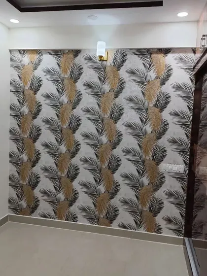 A bedroom wall with a feather-themed wallpaper in neutral tones. The design is elegant and calming, perfect for a restful space.