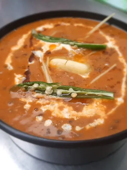 This is our Dal Makhani, slow-cooked for hours until it's perfectly creamy and rich. We finish it with a swirl of cream and a pat of butter, making it the ultimate comfort dish.