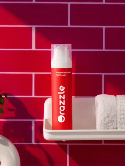 This bathroom shelfie for Orazzle's watermelon toothpaste places the product in a relatable, everyday setting. The bold red tile background makes the product stand out while feeling authentic.