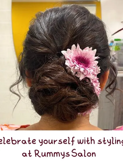 A soft and romantic low bun adorned with fresh pink flowers. This is a simple way to celebrate yourself and add a touch of elegance to your look.