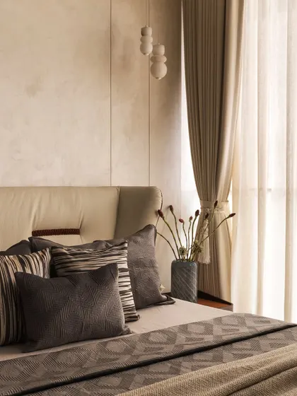 Beige is never boring when done right. In this room, I layered various shades and textures of grey and beige, from the upholstered headboard to the throw pillows and linens, to create a sophisticated, monochrome look.