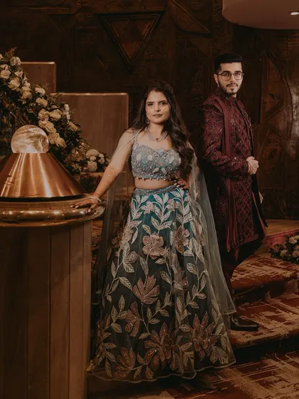 A full-length portrait of the couple in their coordinated Sangeet outfits, posing with style.