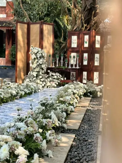 A simple yet beautiful white floral aisle, creating a natural and elegant path for the wedding ceremony.