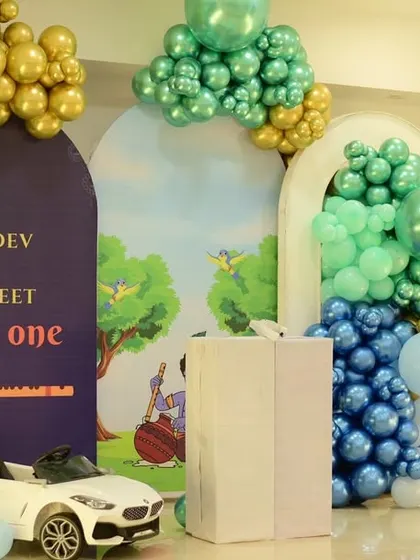 A divine first birthday for twins Aadidev and Aprajeet with a Little Krishna theme. The decor features a blue and green color palette with gold accents.