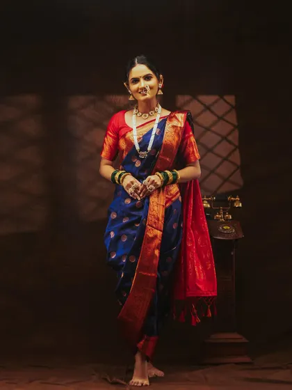 A full-length shot of the model in a classic Nauvari saree, showing the traditional way it's draped.