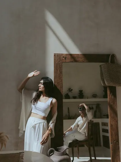 A creative composition using a mirror to capture both partners in a single frame. This artistic shot from a Bali villa plays with reflection and perspective, telling a story of connection even when they are not looking at each other.