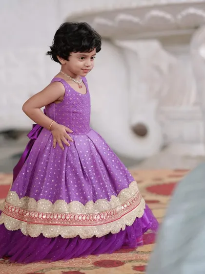A beautiful lavender gown made from brocade fabric with a layered net underskirt.