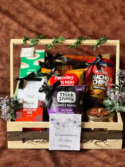 A final look at the open engagement hamper before it's wrapped. The items are carefully arranged and decorated with a simple green vine.