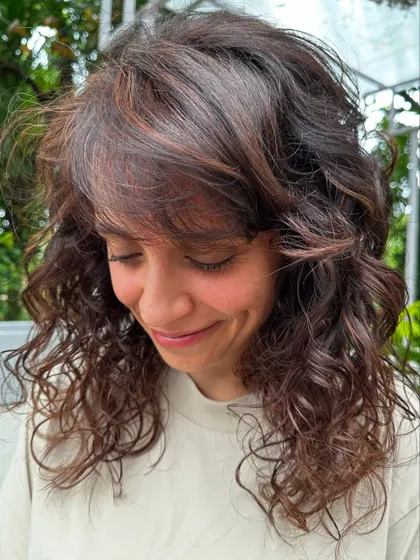 That happy smile says it all. She's feeling her new curly cut and color, and so are we.