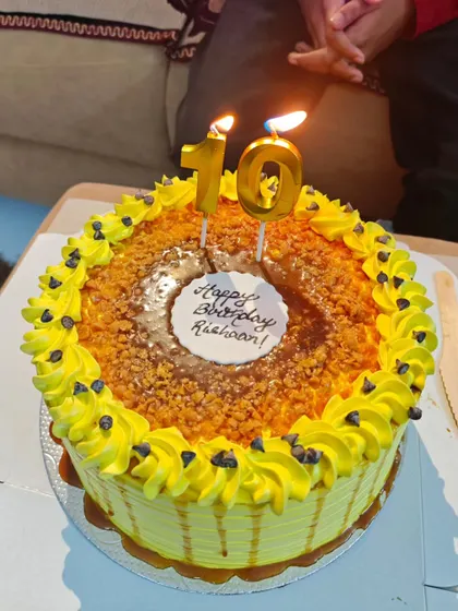 A classic butterscotch cake with homemade caramel sauce and crunchy nuts, ready for a 10th birthday celebration.