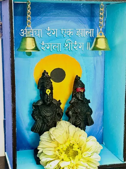 A special wooden mandir decor piece with a Vitthal theme, created for Ashadhi Ekadashi. It features the idols against a painted backdrop with hanging bells.