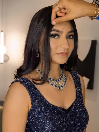 A candid moment during the final touches, showing the intensity of the blue smokey eye.