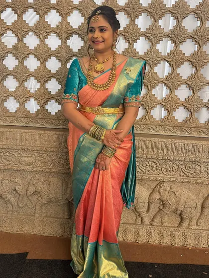 This lovely aunty is ready for a wedding in her peach and teal Kanjivaram. I designed a contrasting teal blouse with delicate embroidery to complete her look.