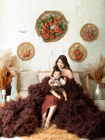 A mother and her baby boy in a beautiful bohemian-themed setup. The rich brown tones and natural textures create a warm and inviting atmosphere.