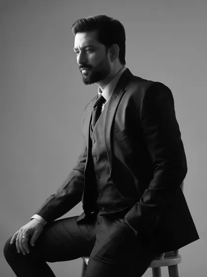 A classic black and white version of the suited portrait of Aadesh Chaudhary, adding a timeless and sophisticated feel.