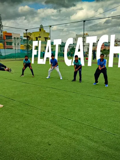A coach leads a flat catching drill on the turf. We emphasize the importance of a low body position and watching the ball into the hands.