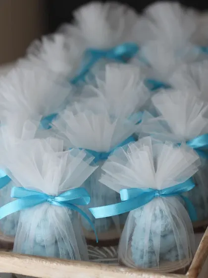 A tray of blue Rose Bear candles, all packed and ready for a baby shower event.