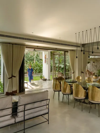 A modern dining room with sliding glass doors that open completely to the patio and garden. The design encourages an effortless flow between indoor dining and outdoor living, perfect for entertaining or daily family life.