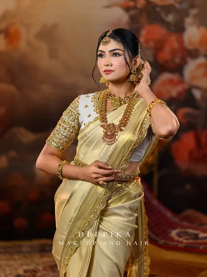 The model posing gracefully, showcasing the rich texture of the golden saree and the intricate details of the embroidered blouse.
