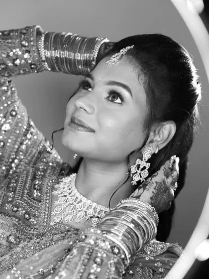 A beautiful black and white portrait of a bride looking up, framed by a ring light.