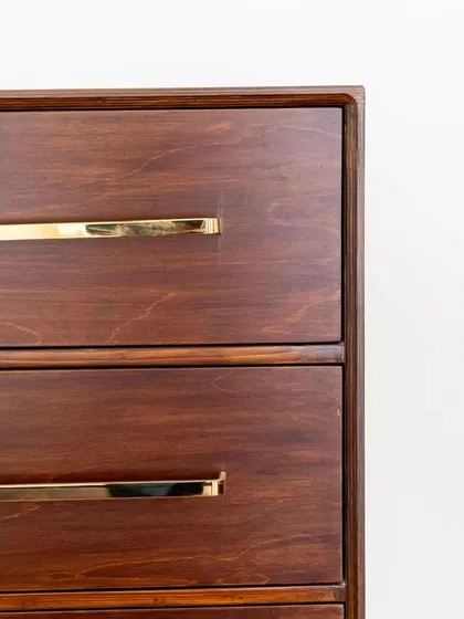 A close-up of the drawers, showing the beautiful wood grain and the elegant brass handles.