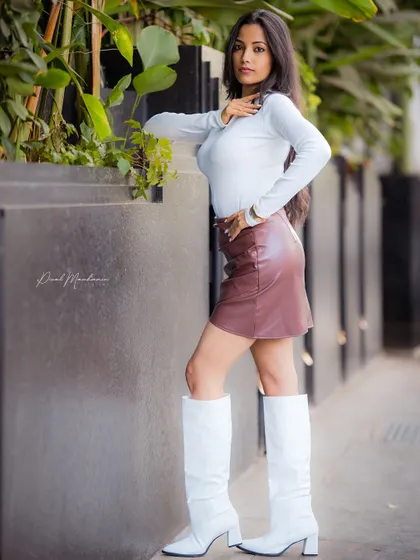 This is a powerful, modern look. The combination of the leather skirt and white boots creates a high-fashion statement, perfect for a portfolio update.