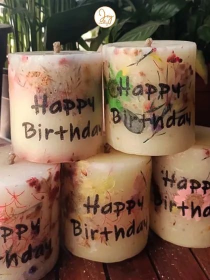 A collection of our "Happy Birthday" floral love pillar candles. A client ordered these to have thoughtful, handmade gifts ready for her friends' special days.