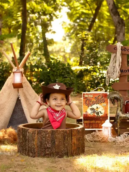 A cute cowboy peeking out of a wooden tub, enjoying his imaginative playtime in the great outdoors.