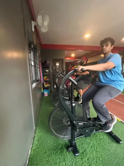 A client pushes hard on the air bike, a brutal but effective tool for HIIT workouts.