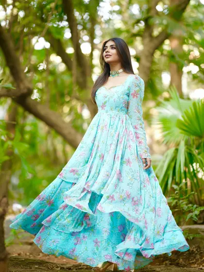 A dreamy, flowy Anarkali gown in a sky-blue floral print. The tiered layers of the skirt create beautiful movement.