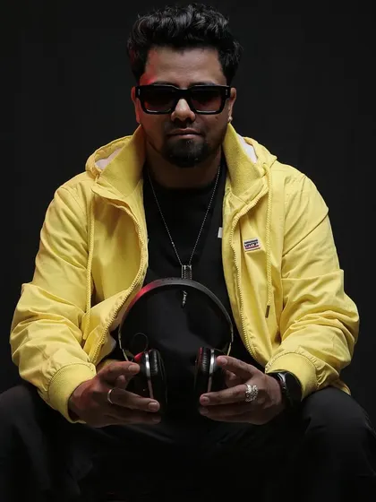 A seated portrait holding my headphones. This shot captures my readiness and focus before a big set.