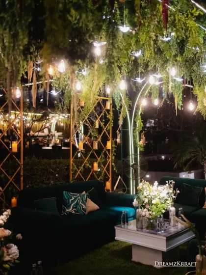 Another view of the foliage-laced lounge, highlighting the gold geometric backdrops and candle walls. The combination of textures and lighting creates a rich and inviting atmosphere.