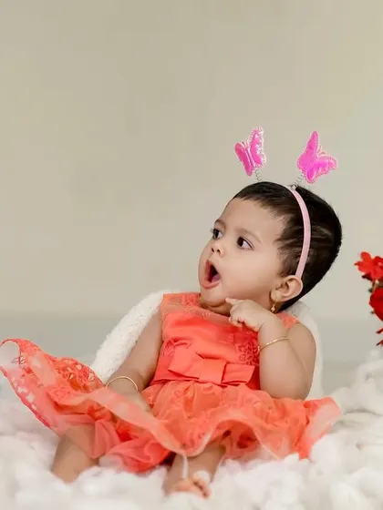 A little butterfly princess surrounded by red roses. This studio setup is simple yet magical, with a soft, cloud-like floor.