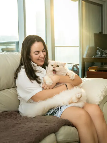 A candid moment of a woman laughing as her fluffy white cat lets out a big yawn. It’s these unscripted, slightly chaotic moments at home that often make for the best pictures.