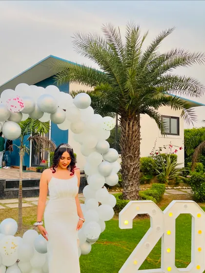 Posing with my "20" marquee lights and birthday decorations. This shot captures the festive atmosphere of my party.