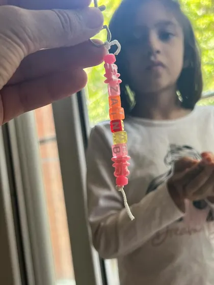 A close-up of a beautiful, personalized keychain with the name "Zainab". The kids love picking out the beads and spelling their names.