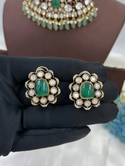 A close-up of our versatile floral stud earrings. These are available in multiple colors like emerald green and ruby red, and can be paired with many different necklaces.